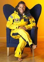 Emma Richards MBE in yellow suit seated