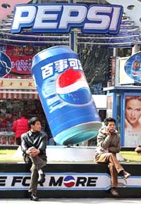 Chinese shoppers rest near a Pepsi advertisement
