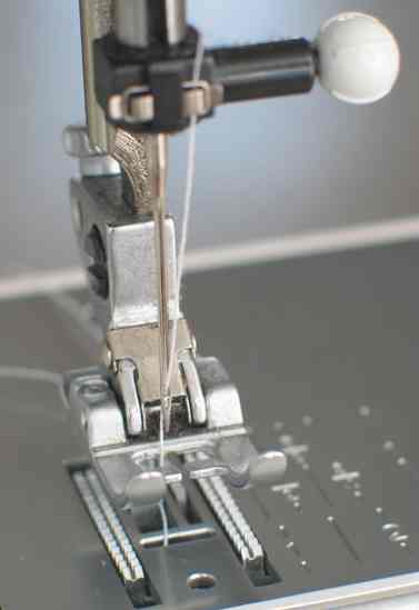 sewing machine needle plate, foot and toothed transport mechanism